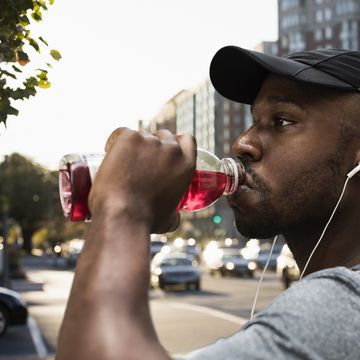 black runner drinking juice in city