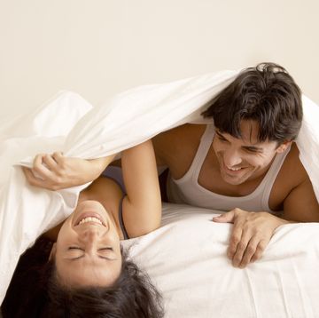 couple laughing in bed together
