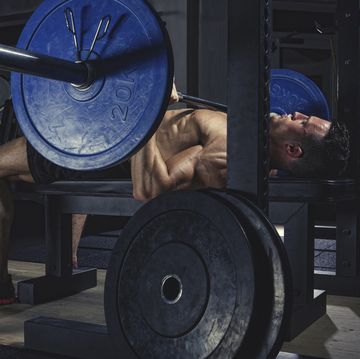 physical athlete doing barbell bench presses