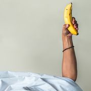man houdt banaan en vruchtensap vast in bed
